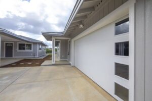 Modern Hawaii home with large pocketing glass doors and sustainable wood siding by Atlas Construction Inc.