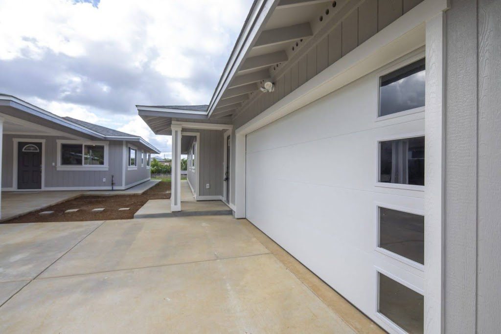 Modern Hawaii home with large pocketing glass doors and sustainable wood siding by Atlas Construction Inc.